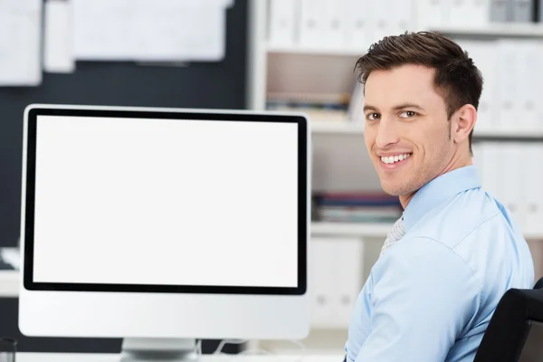 Empresário sentado na frente de um monitor em branco — Fotografia de Stock