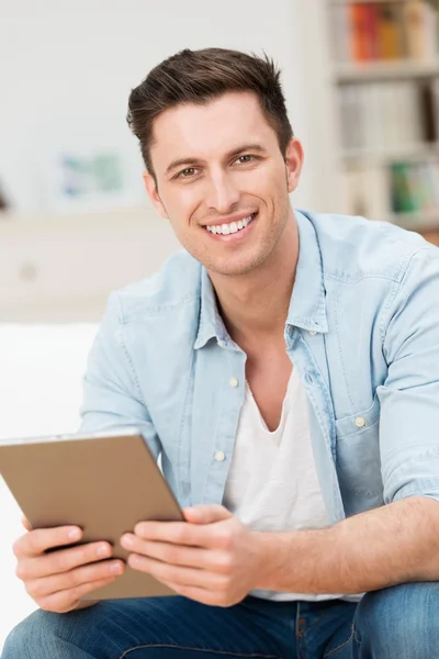 Guapo joven amistoso sosteniendo una tableta —  Fotos de Stock