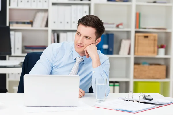 Geschäftsmann sitzt tagträumend am Schreibtisch — Stockfoto