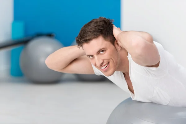 Pilates egzersizleri yapıyor, sağlıklı, zinde genç adam — Stok fotoğraf