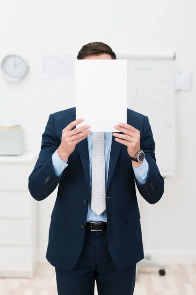 Homme d'affaires caché derrière une feuille de papier — Photo