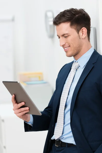 Stijlvolle jonge zakenman lezen van een tablet-pc — Stockfoto