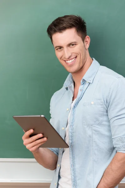 Genç adam bir tablet tutan gülümseyerek — Stok fotoğraf