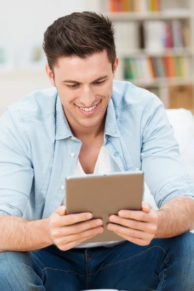 Handsome man reading on his tablet computer — Stock Photo, Image