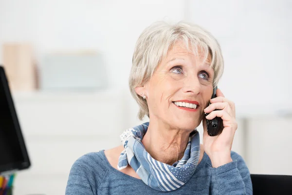 Sonriendo atractivas mujeres mayores usando un móvil — Foto de Stock