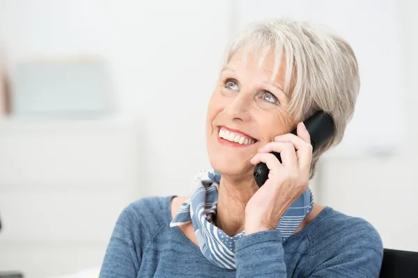 Senior vrouw chatten op haar mobiele telefoon — Stockfoto