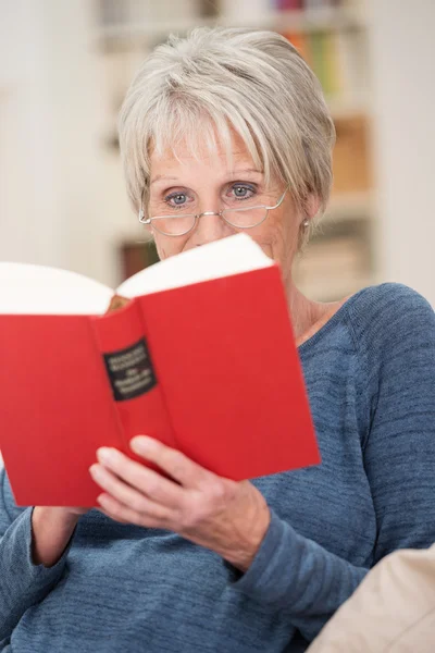 Seniorin entspannt mit einem Buch — Stockfoto