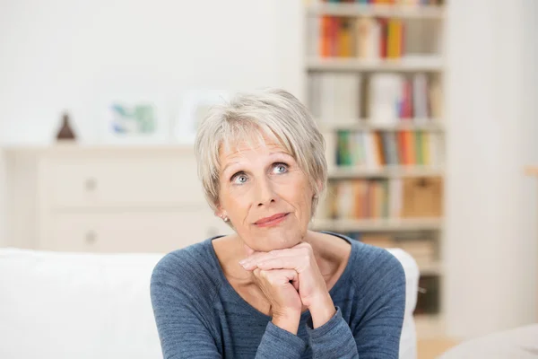 Elderly attractive woman sitting reminiscing — Stock Photo, Image