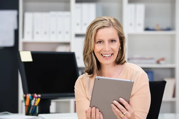 Femme d'affaires souriante tenant une tablette — Photo