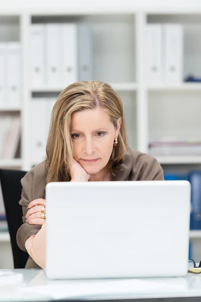 Businesswoman staring glumly at her laptop — Stock Photo, Image
