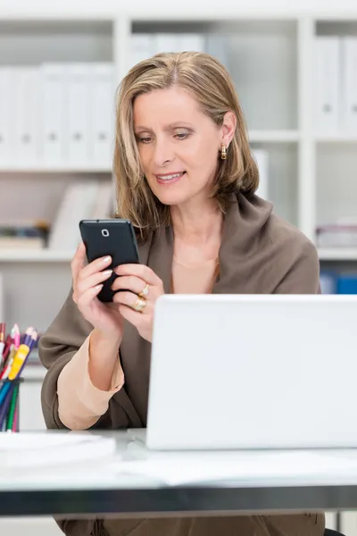 Attractive businesswoman reading an sms — Stock Photo, Image