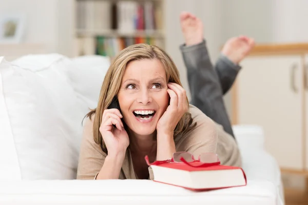 Frau lacht, als sie mit ihrem Handy chattet — Stockfoto