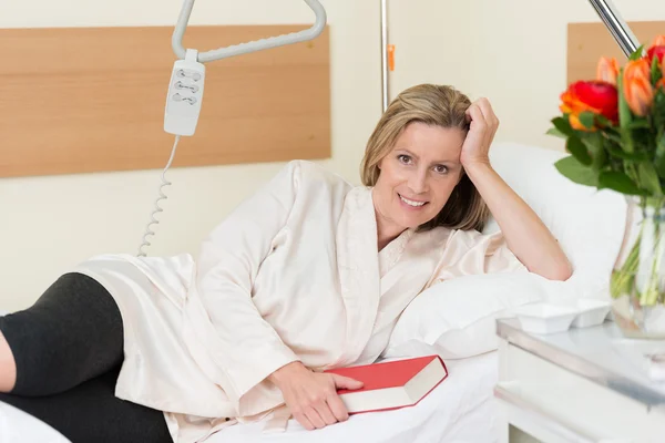 Smiling woman lying on a hospital bed — Stock Photo, Image