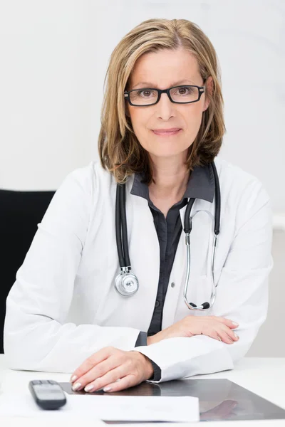 Médica sentada em sua mesa — Fotografia de Stock