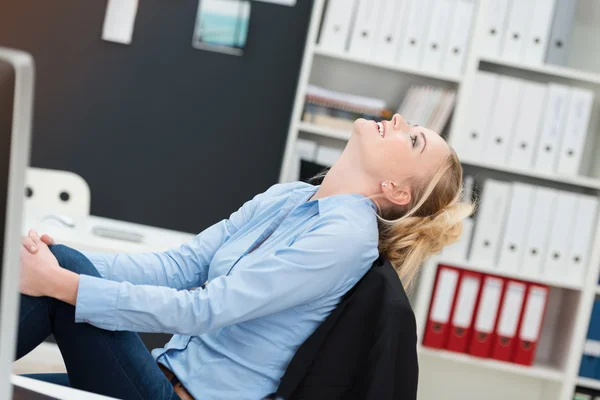 Smiling happy businesswoman sitting daydreaming — Stock Photo, Image