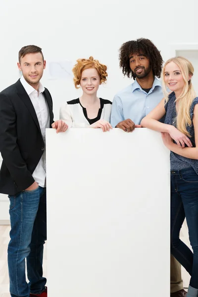 Group of businesspeople with a blank sign — Stock Photo, Image