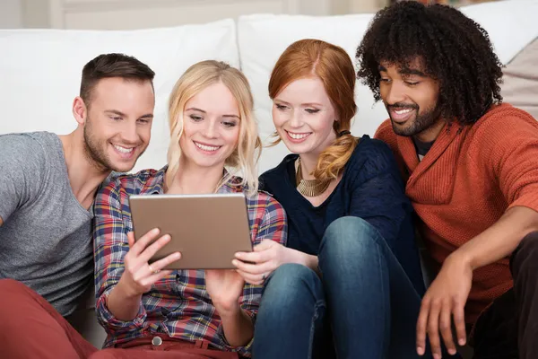 Grupo de jóvenes amigos felices usando una tableta — Foto de Stock