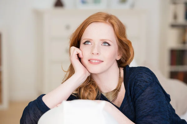 Beautiful young woman sitting thinking — Stock Photo, Image