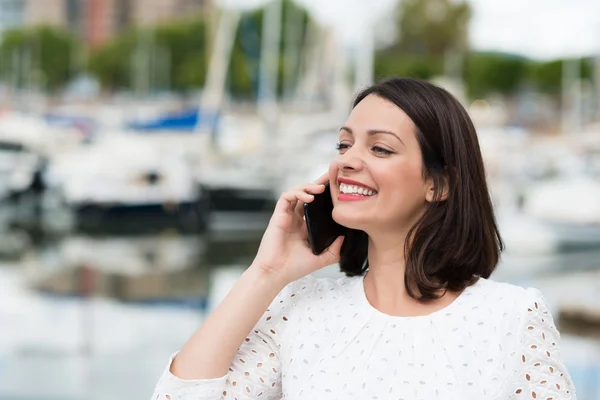 Vrouw die lacht als ze chats op mobiel — Stockfoto