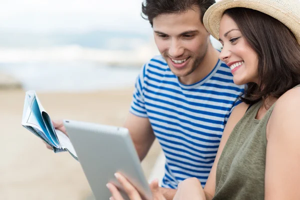 Couple looking up directions on tablet — Stock Photo, Image