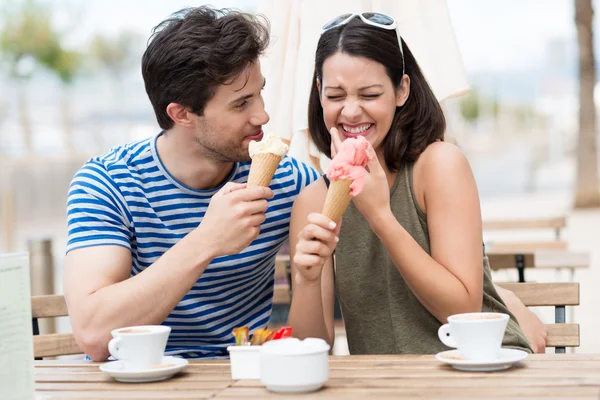 Laughing couple eating ice cream cones — Stock Photo, Image