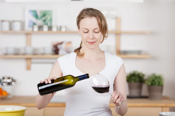 Žena nalil sklenici vína — Stock fotografie