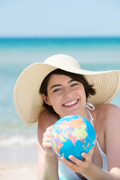 Young woman at beach with globe — Stock Photo, Image