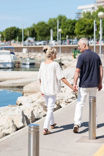 Couple strolling past boat harbour — Stock Photo, Image