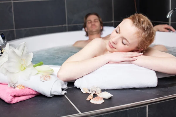 Kvinnan avkopplande med man i Jacuzzi — Stockfoto