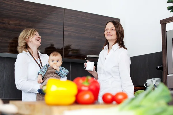 Mothers in kitchen with baby — Stock Photo, Image