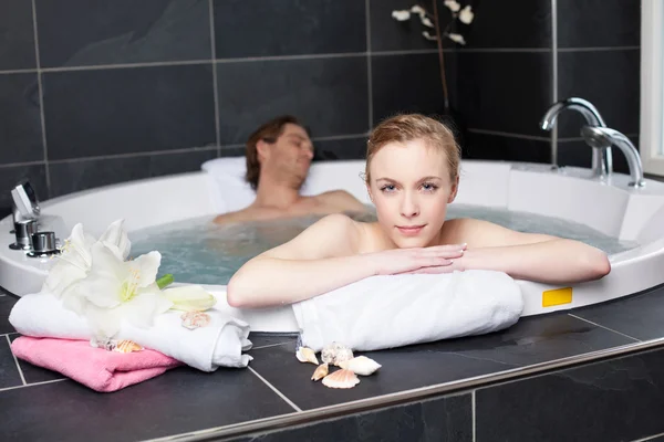 Kvinnan avkopplande med man i Jacuzzi — Stockfoto