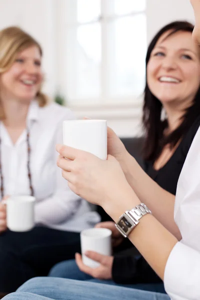 Amigos femininos segurando xícaras de café — Fotografia de Stock