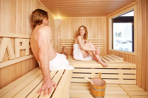 Mujer mirando al hombre en la sauna — Foto de Stock