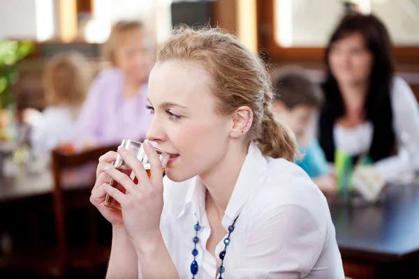 Kvinna som njuter av te i restaurangen — Stockfoto