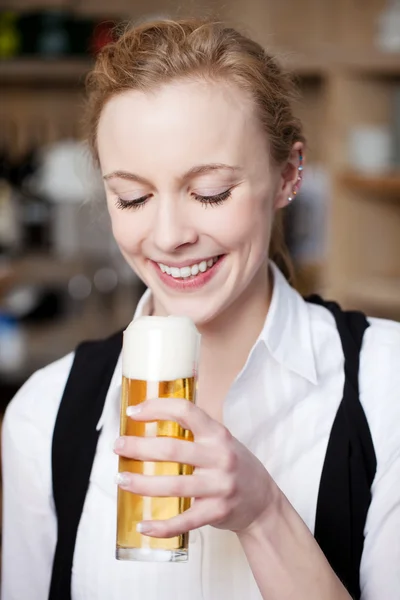 Femme souriante avec une pinte de bière — Photo