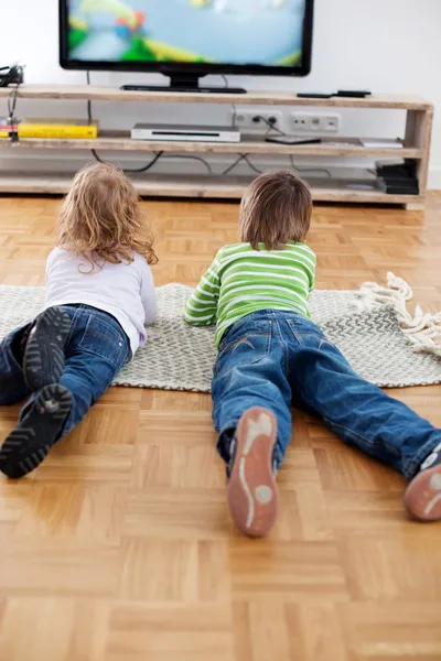 Bror och syster tittar på TV — Stockfoto