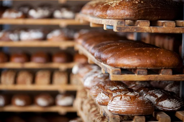 Breads displayed on shelves in bakery — Stock Photo, Image