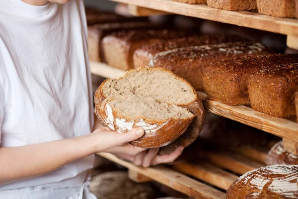 Verkoopster breken brood — Stockfoto