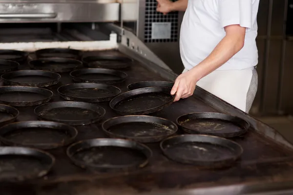 Trabalhador em pé junto ao forno — Fotografia de Stock