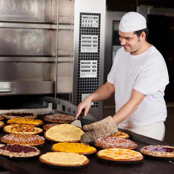 Trabalhador assar várias tortas — Fotografia de Stock