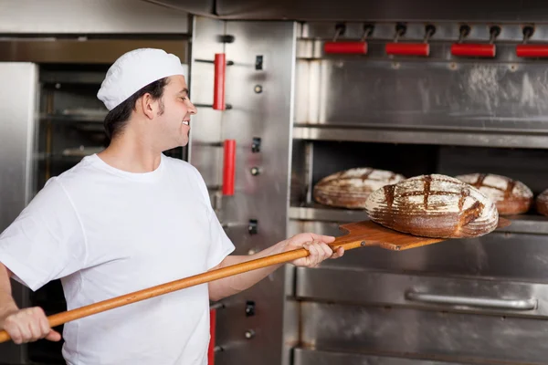 Chef at bakery with fresh bread — Stock Photo, Image