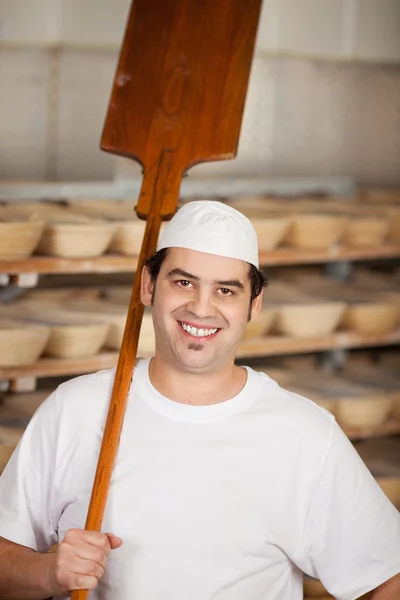 Male worker holding baking spatula — Stock Photo, Image