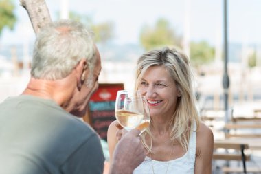 Mature couple toasting with wine clipart