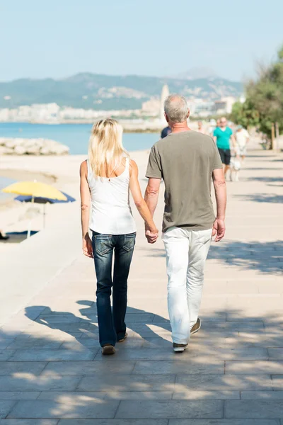 Couple walking on seafront promenade — Stock Photo, Image