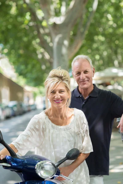 Friendly attractive woman holding scooter — Stock Photo, Image