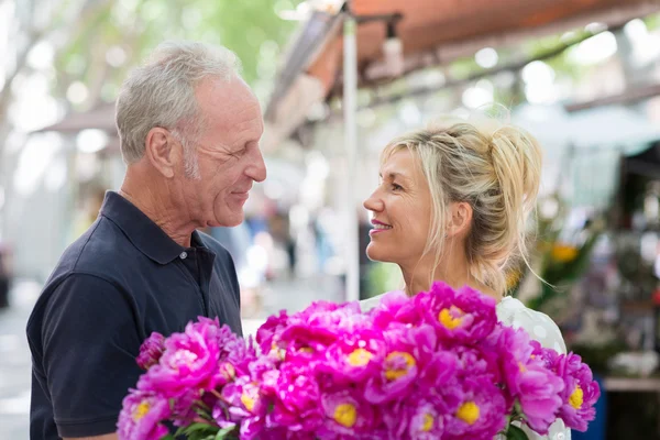 Romantic man giving his wife flowers — Stock Photo, Image