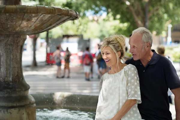 Laughing couple alongside fountain — Stock Photo, Image