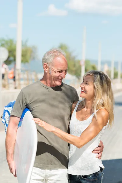 Fit tanned couple going surfing — Stock Photo, Image
