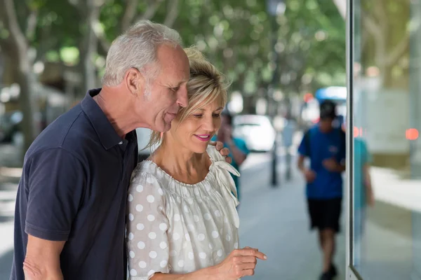 Pareja de mediana edad admirando mercancía de la tienda — Foto de Stock