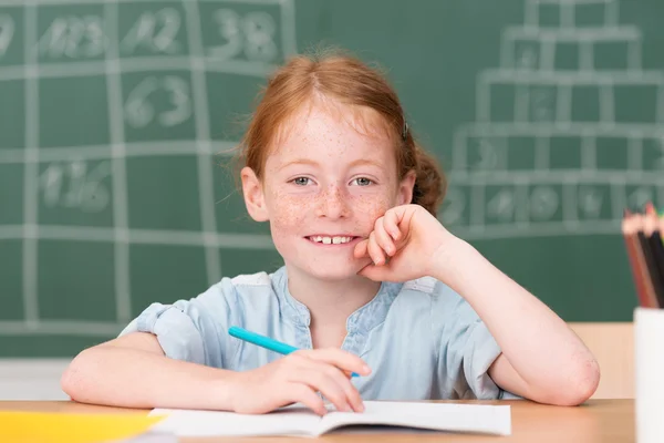 Little schoolgirl in class — Stock Photo, Image